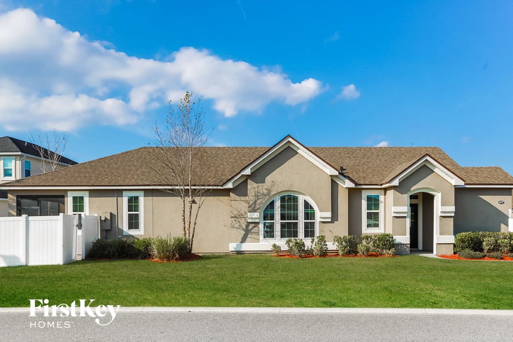 A house with a brown roof and a white fence.