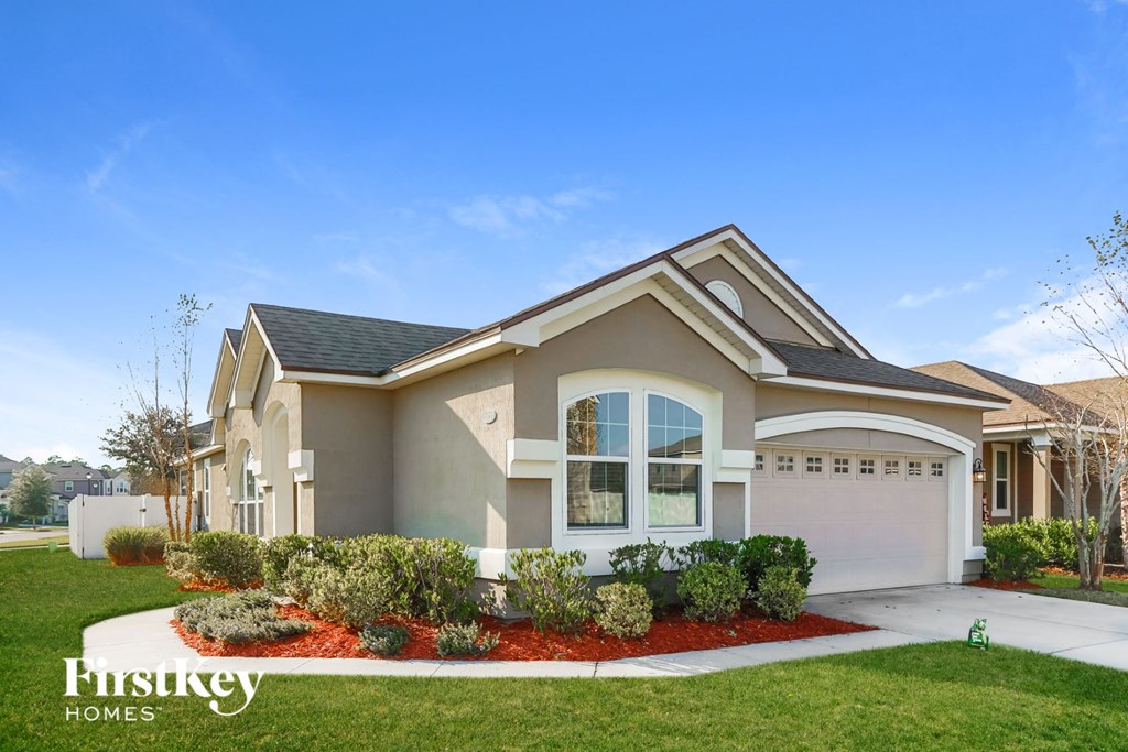A modern house with a well-maintained lawn and a clear blue sky.