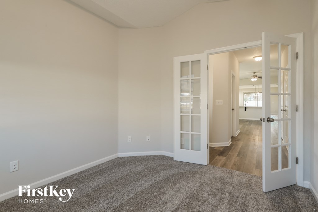 A room with a carpeted floor and a doorway leading to another room.