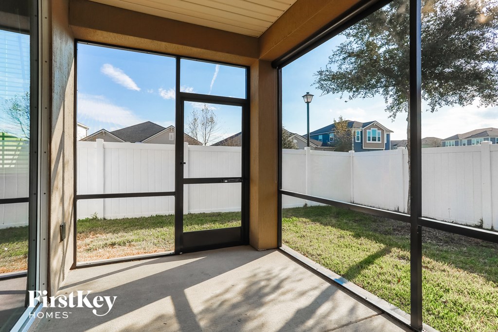 A view of a residential area from a house with a glass door.