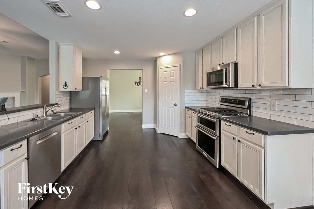 a kitchen with white cabinets and stainless steel appliances