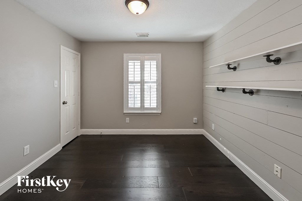 a empty room with a white wall and a window and a white closet