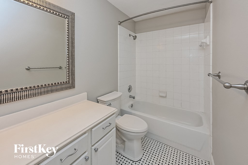 a white bathroom with a tub and toilet and a sink
