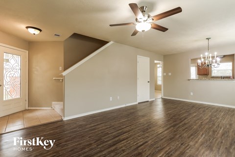 A spacious room with a ceiling fan and wooden flooring.