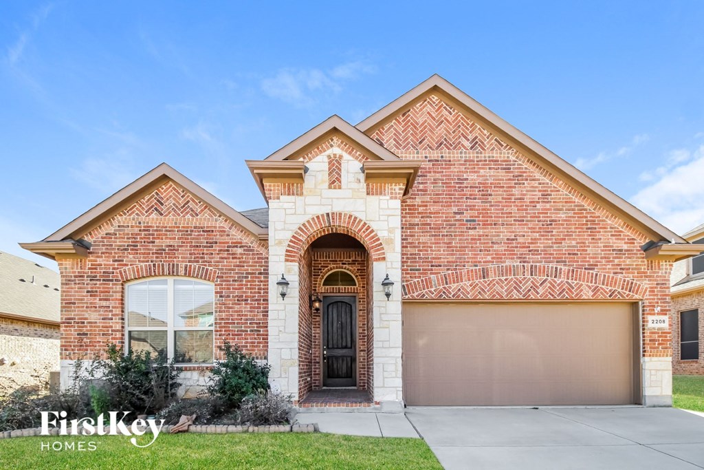 a brick house with a garage door and a driveway