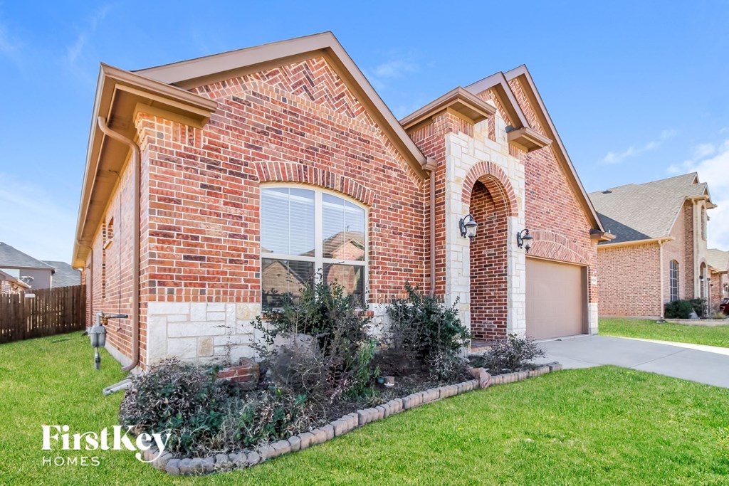 a brick house with a garage and a lawn