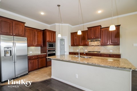 a kitchen with wooden cabinets and granite counter tops and stainless steel appliances