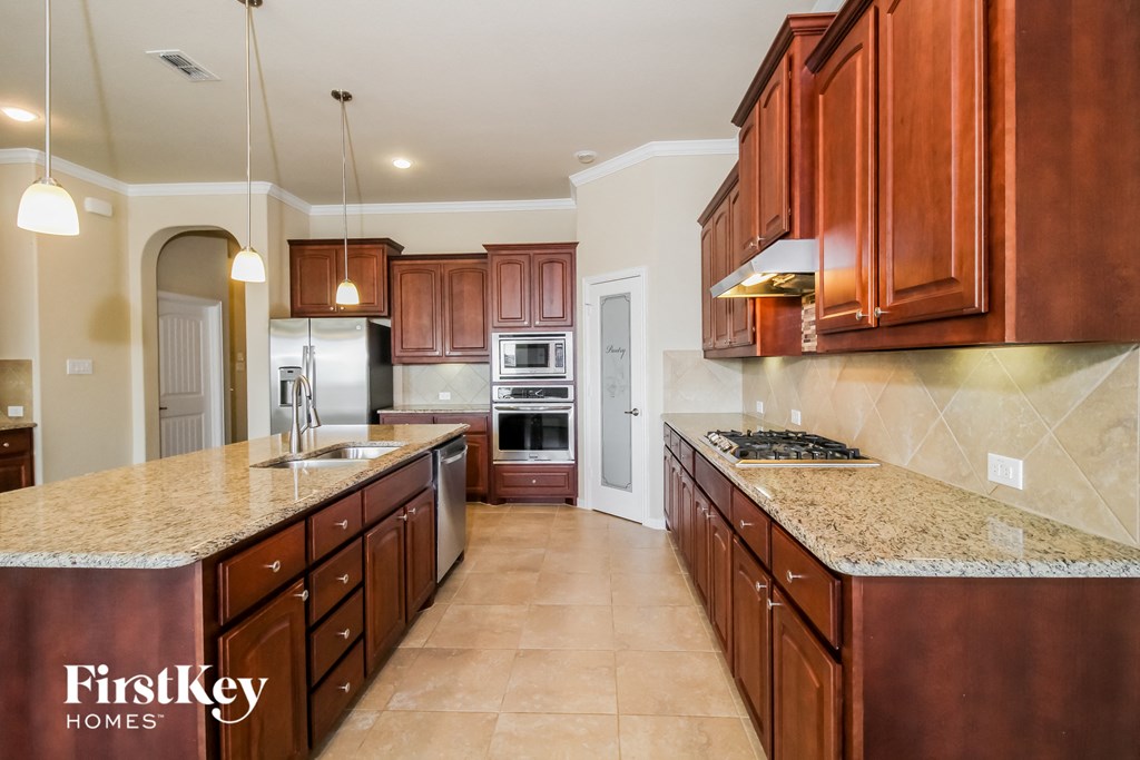 a kitchen with wooden cabinets and granite counter tops and stainless steel appliances