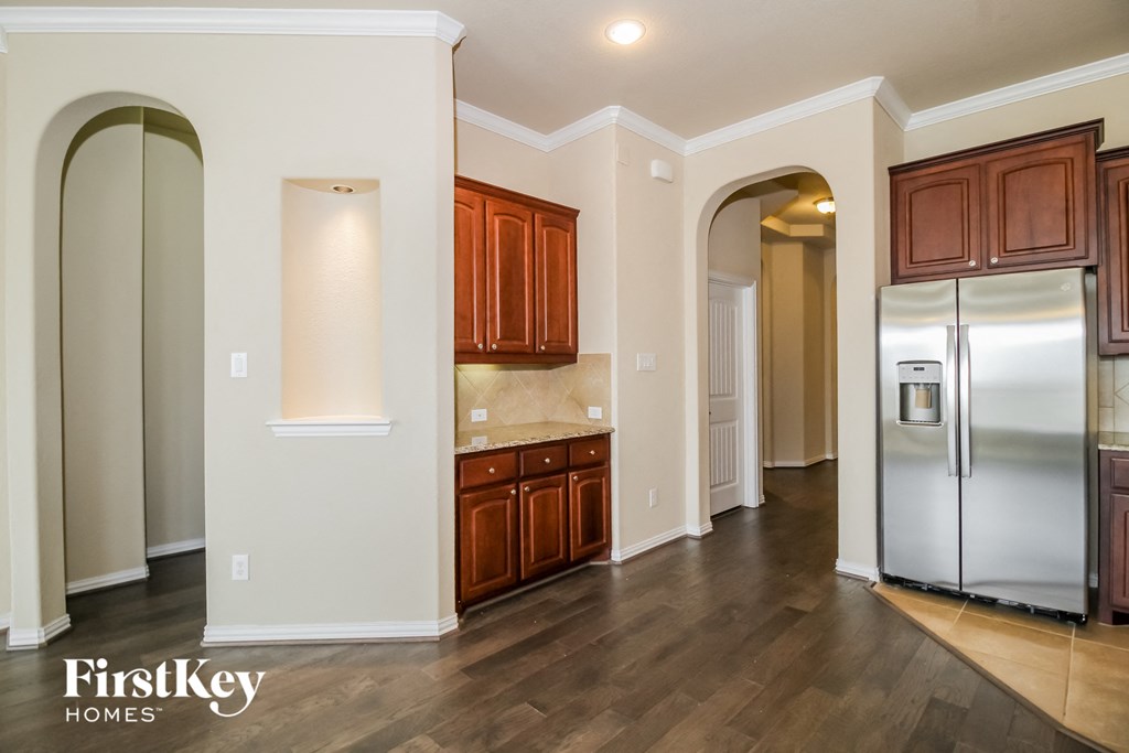 a kitchen with a stainless steel refrigerator and wooden cabinets