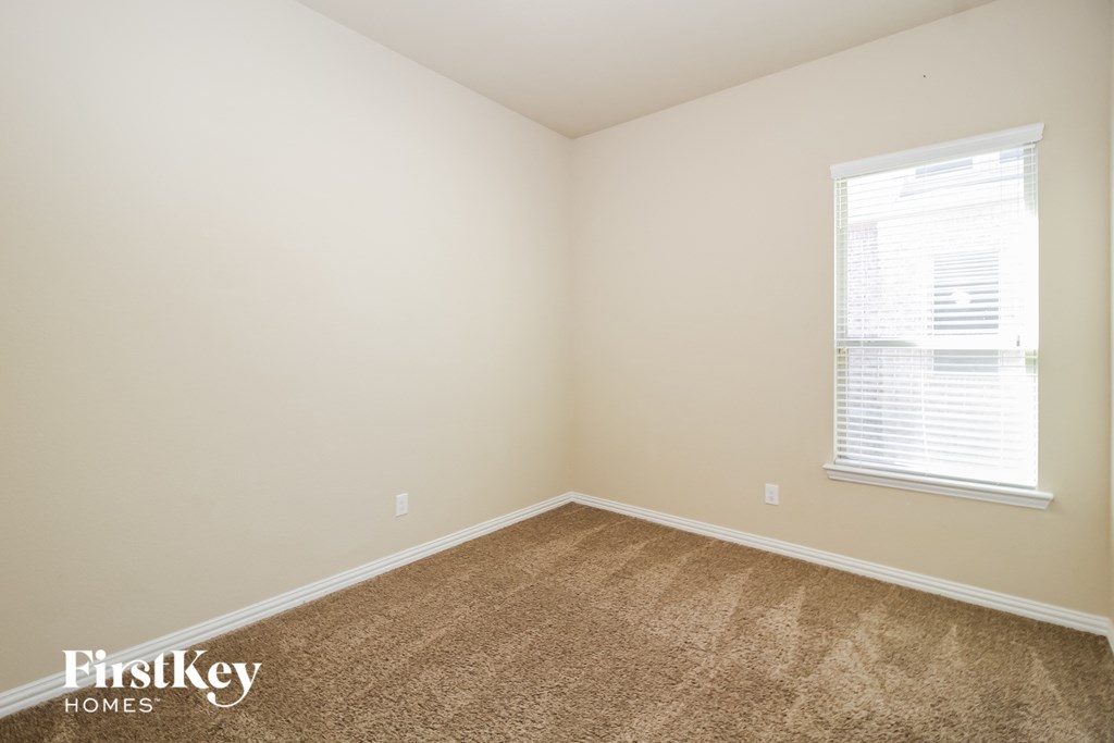 a bedroom with a carpeted floor and a window