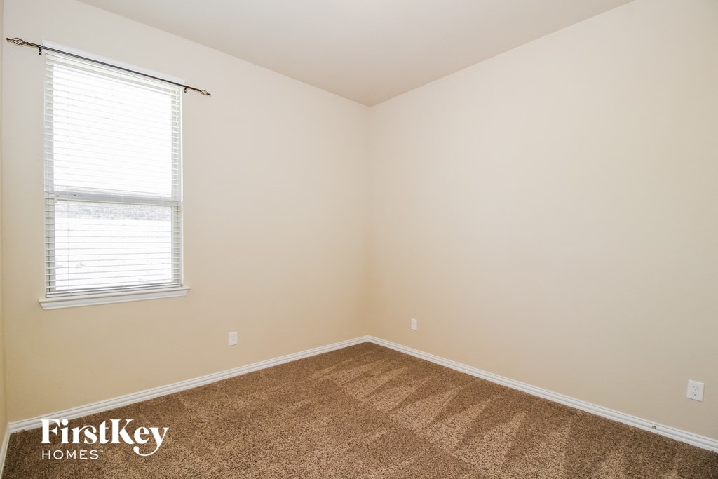 the upstairs bedroom with carpet and a window