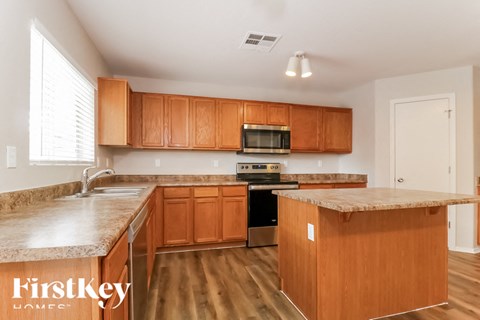 A kitchen with wooden cabinets and a granite countertop.