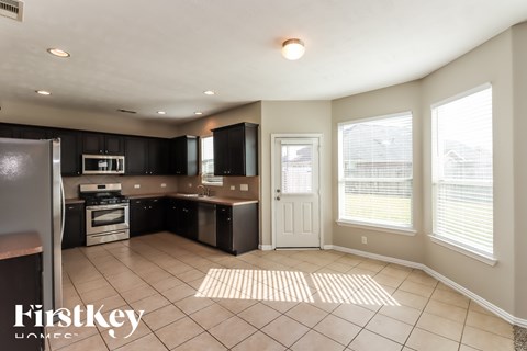 A kitchen with black cabinets and a white door.