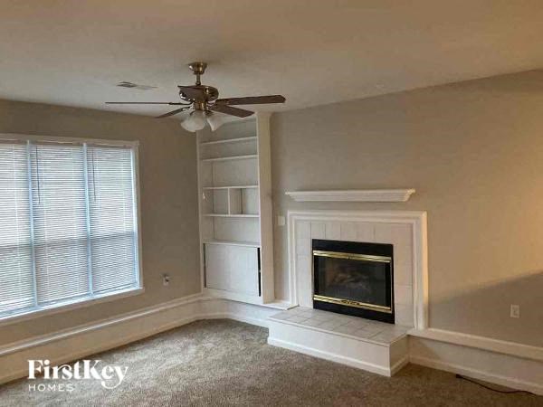 a living room with a fireplace and a ceiling fan