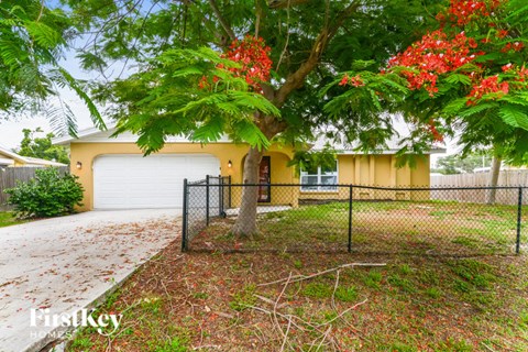a house with a garage and a tree in front of it