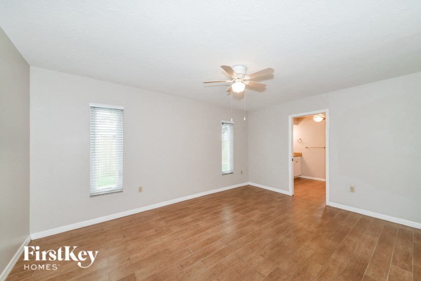 a living room with wood floors and a ceiling fan