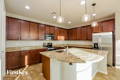 A kitchen with brown cabinets and a granite countertop.