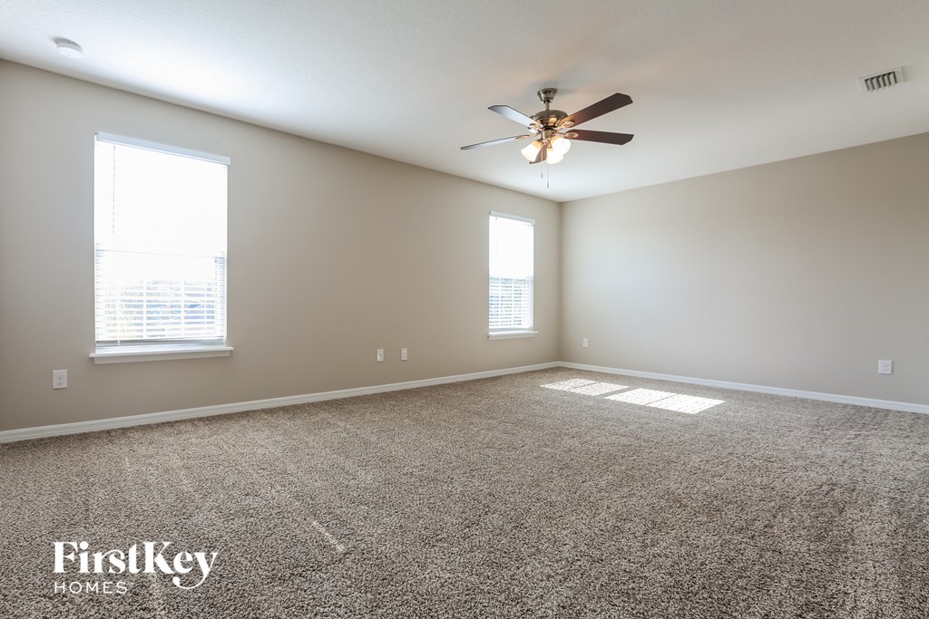 a living room with carpet and a ceiling fan