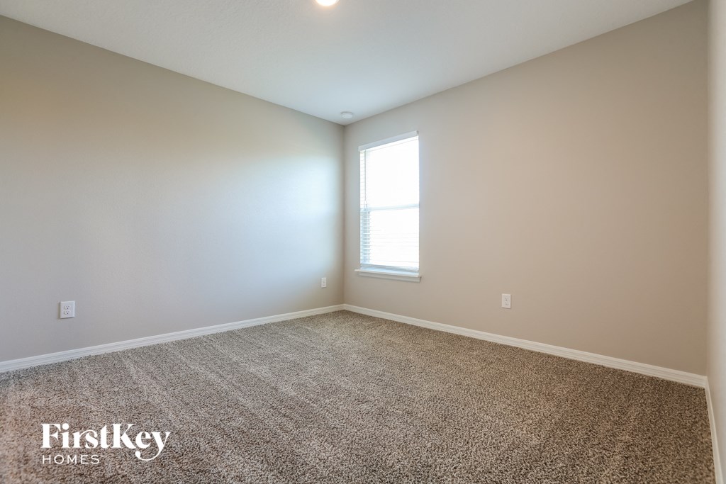 an empty room with carpet and a window