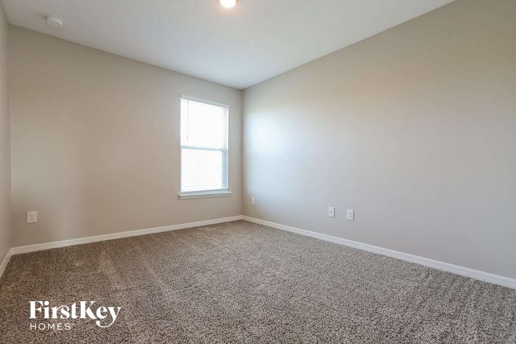 the spacious living room with carpeting and a window