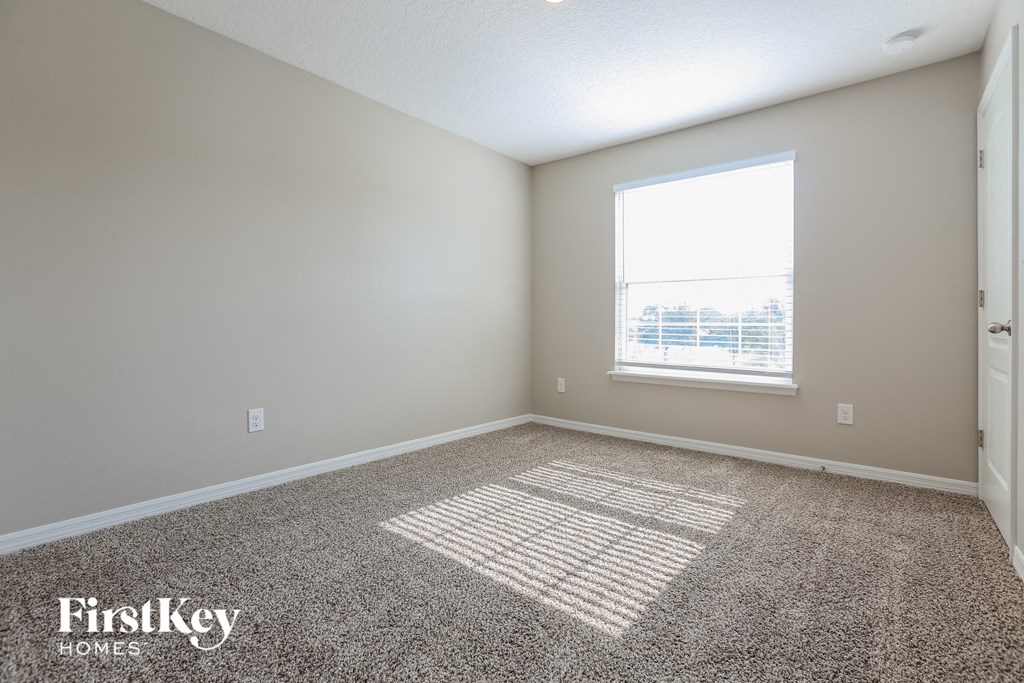 an empty room with carpet and a window