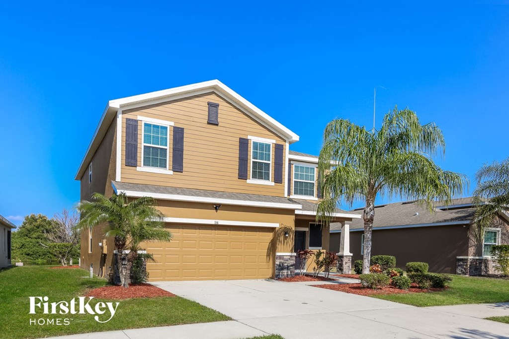 a yellow house with palm trees in front of it