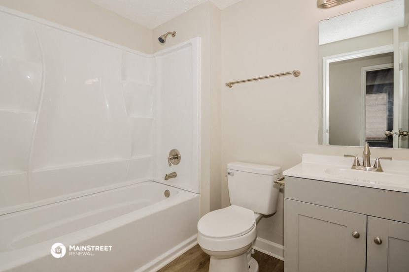 a bathroom with a toilet and a tub and a sink
