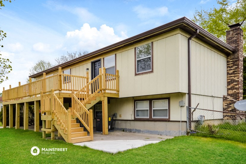 the exterior of a house with a wooden deck and stairs