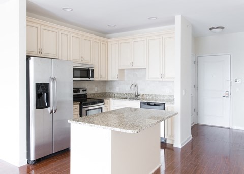 a kitchen with white cabinets and a marble counter top