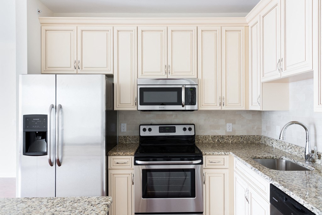 a kitchen with white cabinets and stainless steel appliances