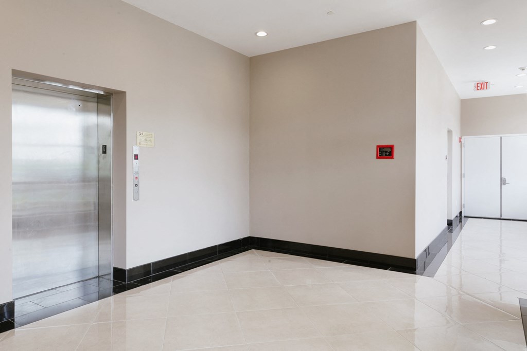an empty hallway with white walls and a glass door