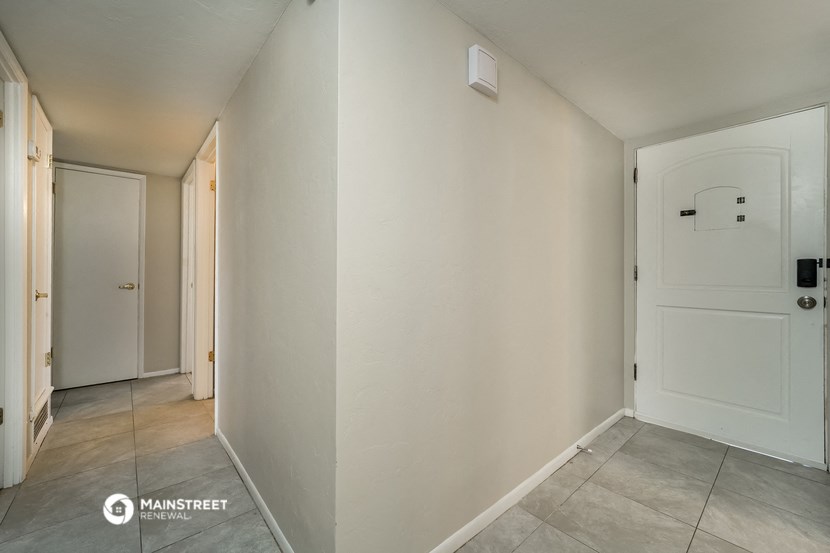 a hallway with white walls and a white door