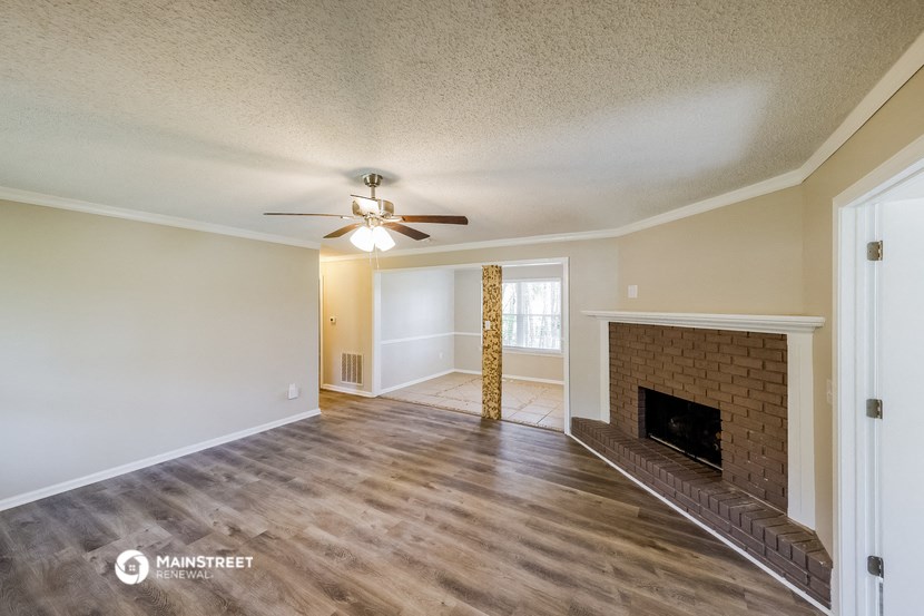 a living room with a fireplace and a ceiling fan