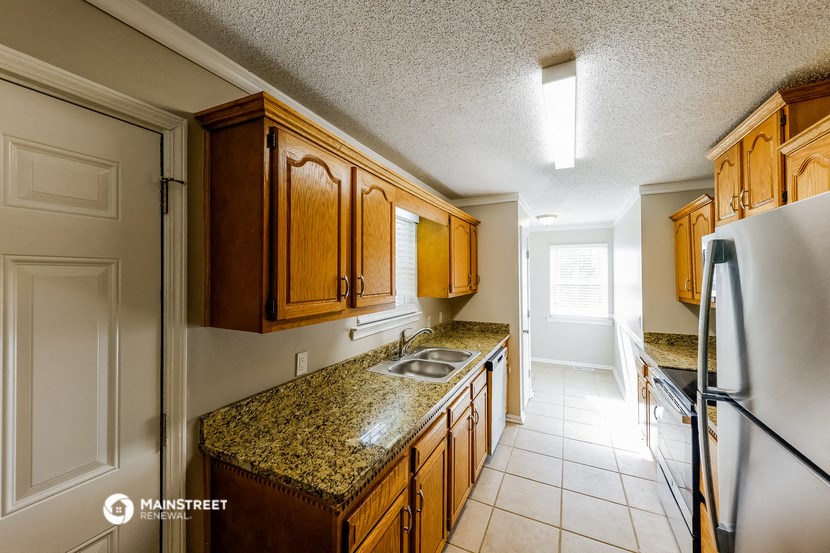 a kitchen with wooden cabinets and granite counter tops