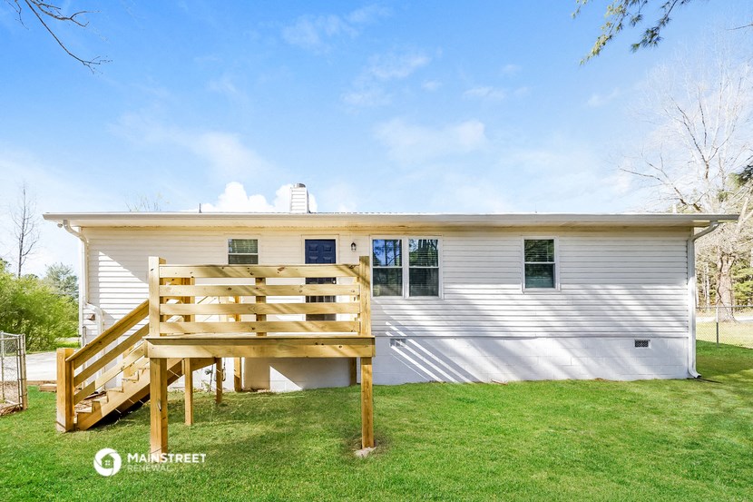 a white house with a wooden deck in front of it
