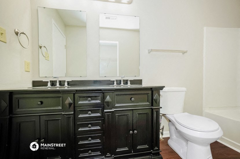 a bathroom with black cabinets and a white toilet