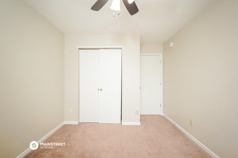 a bedroom with a closet and a ceiling fan