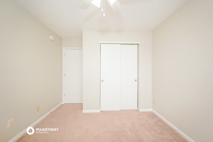 a bedroom with white walls and a closet with white doors