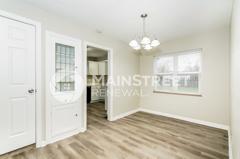 a renovated living room with a door to a hallway and a window