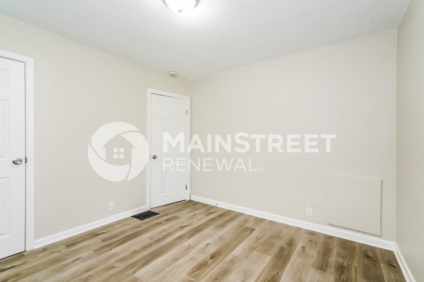 a bedroom with white walls and a white door     and a door