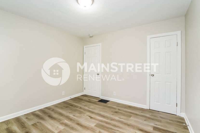 a bedroom with a closet and a white door