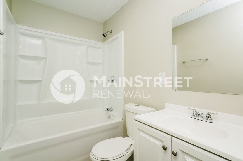 a white bathroom with a sink toilet and tub