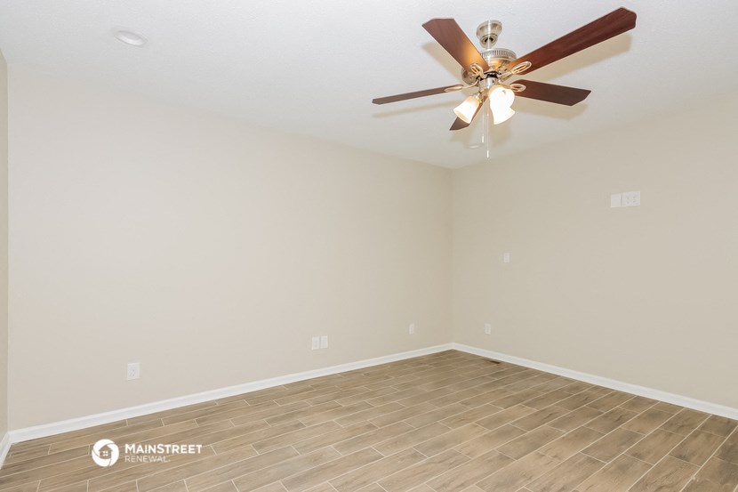 the living room has a ceiling fan and a wood floor