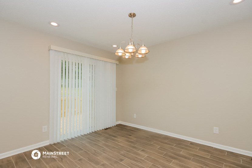 the spacious living room with a large window and wood flooring