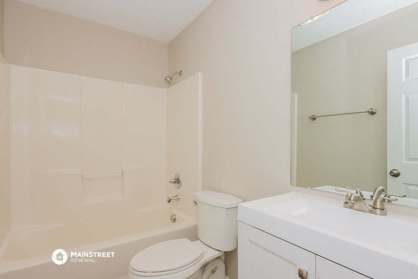 a bathroom with a toilet and a sink and a mirror