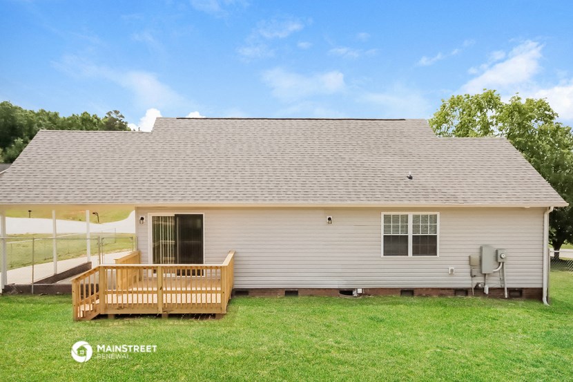 a small white house with a porch and a deck