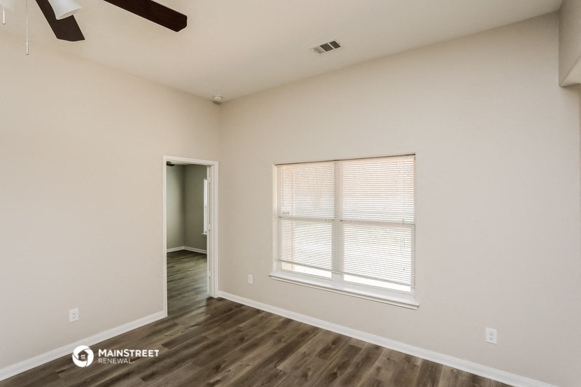 the spacious living room with a large window and wood flooring