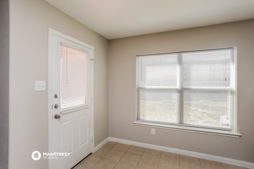a bedroom with a large window and a white door
