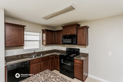 a kitchen with wooden cabinets and black appliances and granite counter tops