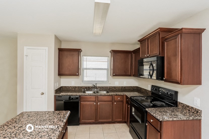 a kitchen with granite counter tops and wooden cabinets